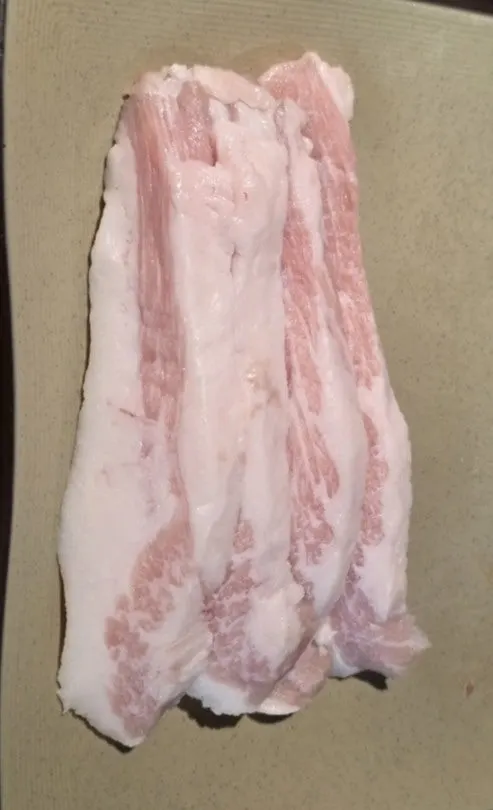 A plate with three raw Duroc pork cuts