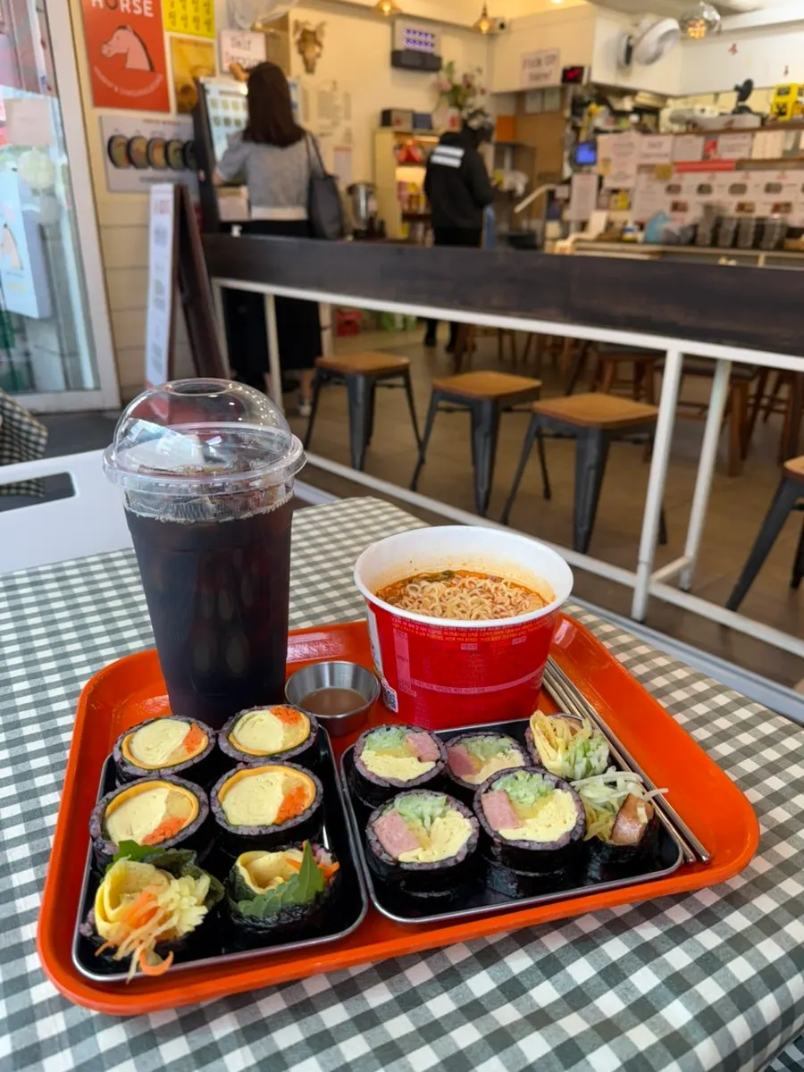Gimbap and mu-pama cup noodles set out on the outdoor table