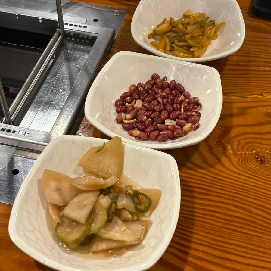 Side dishes of onion sauce, seasoned zha cai, and peanuts