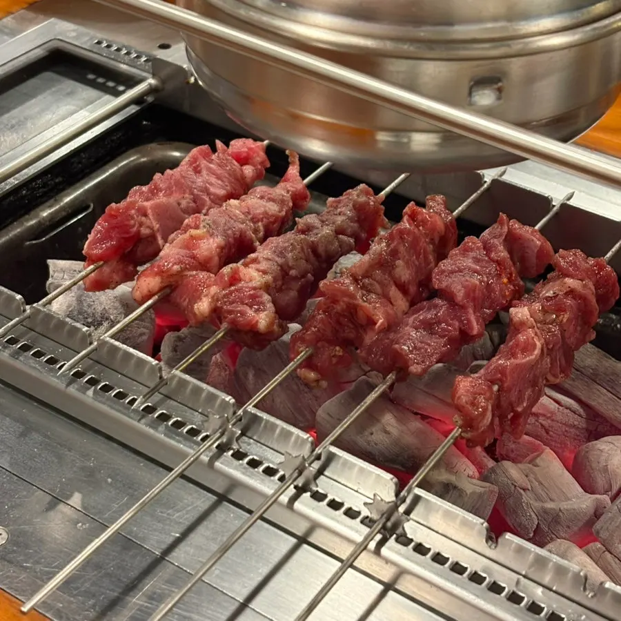 Lamb sirloin skewers cooking over charcoal