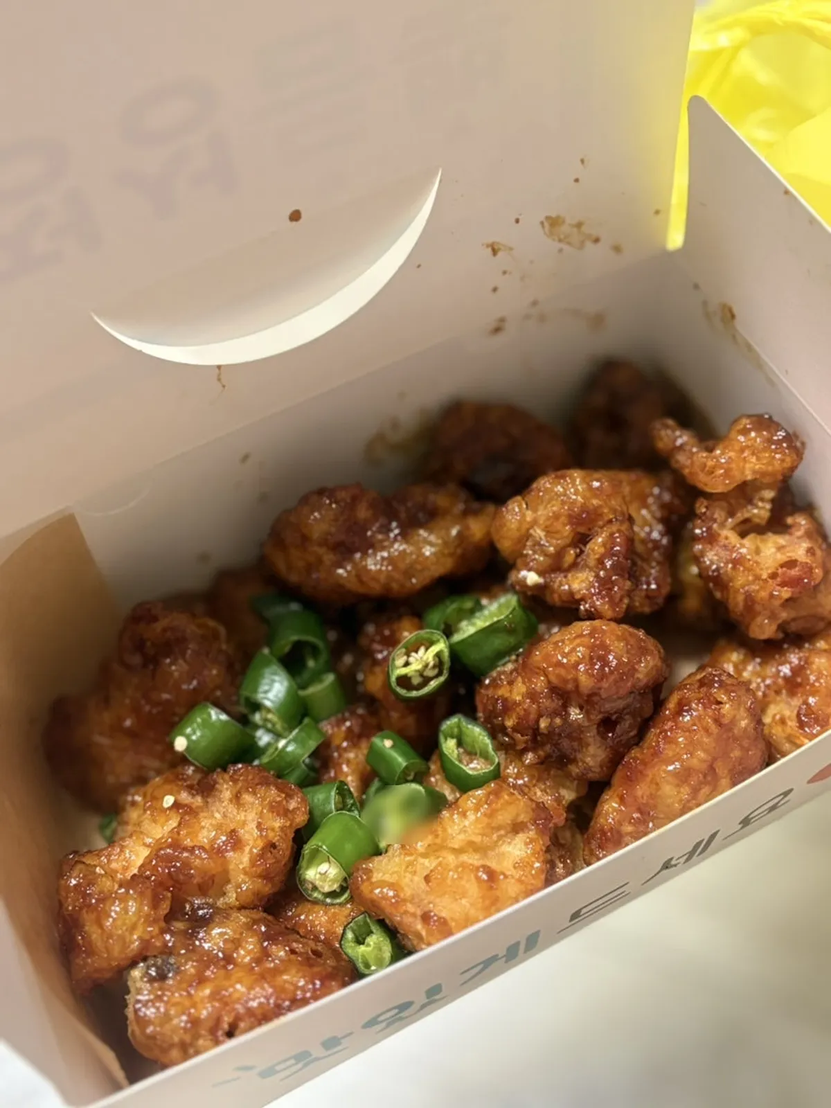 A container of takeout dakgangjeong, still crispy after cooling