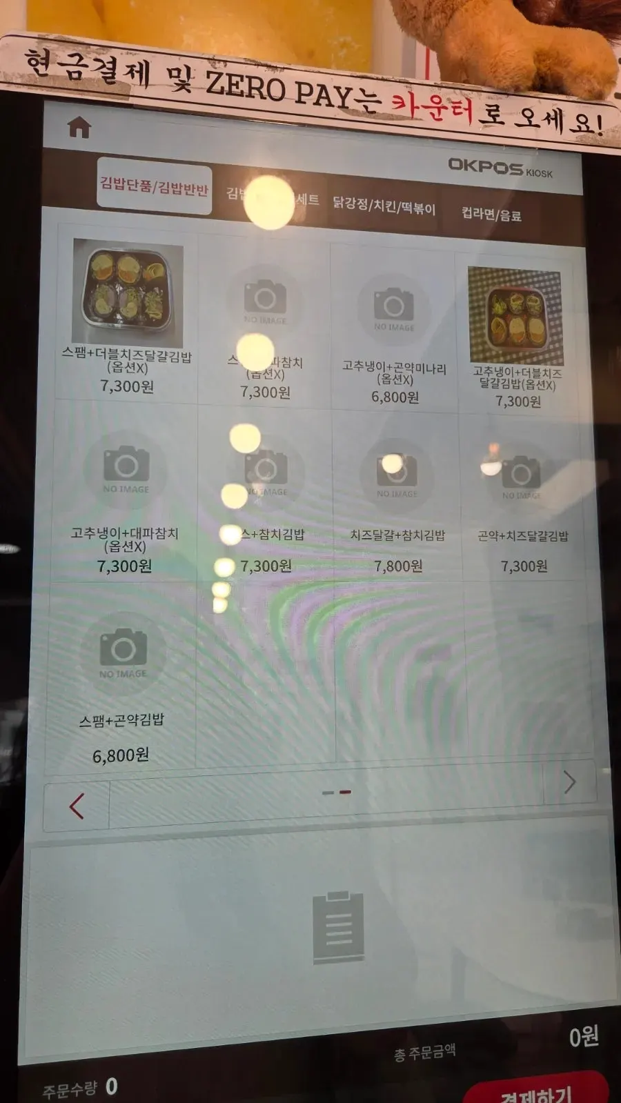 Menu board listing gimbap, tteokbokki, and cup noodles