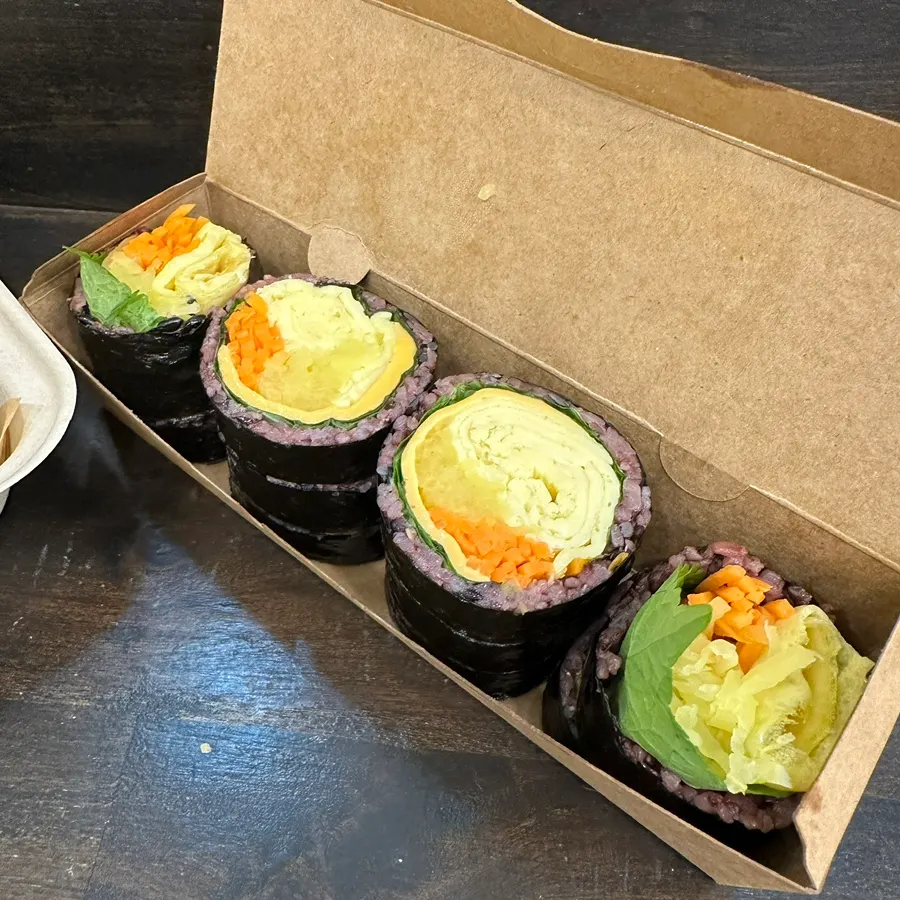Single roll of double cheese egg gimbap packed for takeout