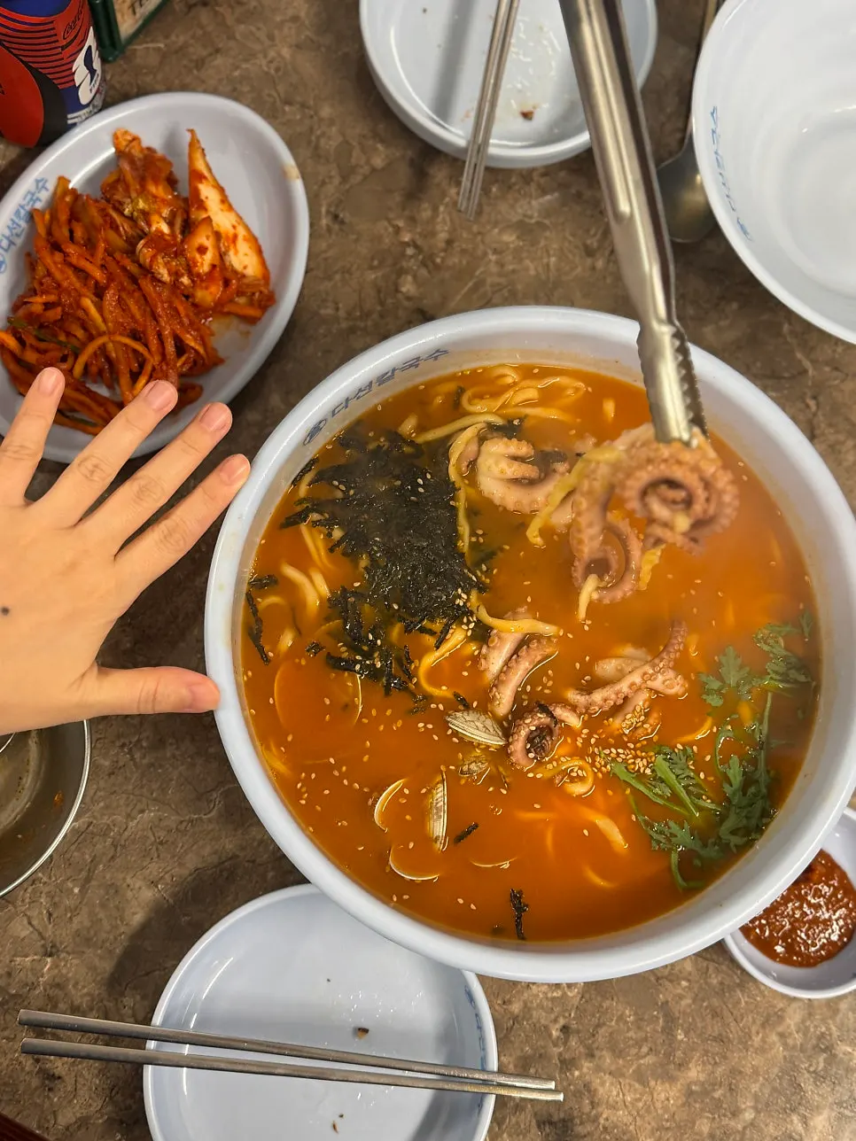 Spicy octopus kalguksu portion compared with a hand