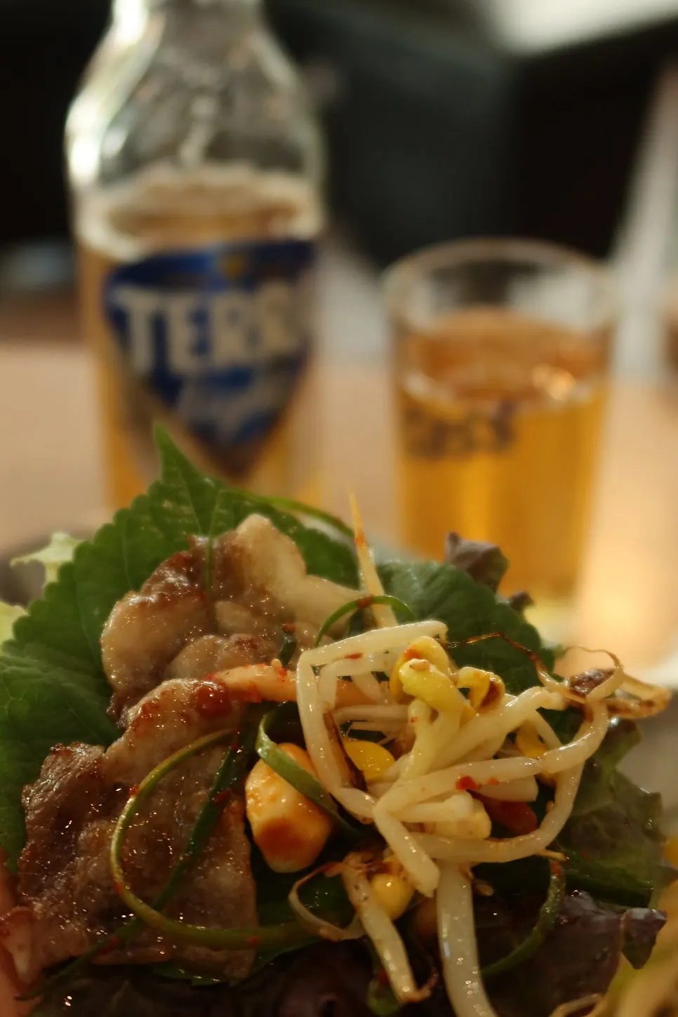 Grilled thin-sliced pork belly with a bottle of Terra Light beer