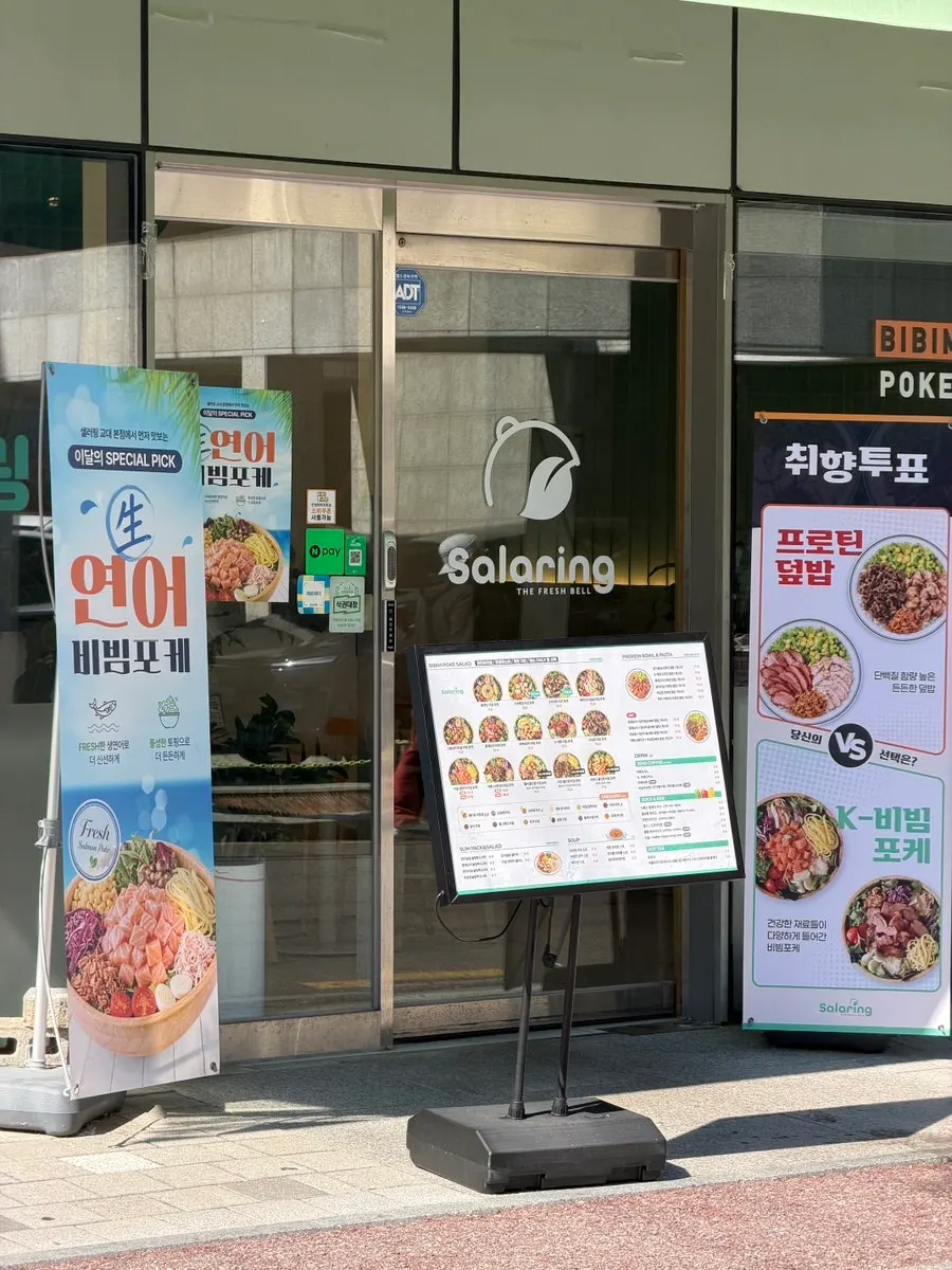 Entrance door with business hours notice at Salering Gyodae Direct Store