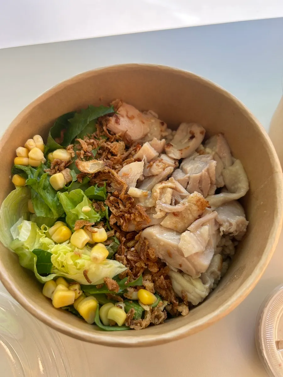 A bite-sized piece of grilled chicken thigh picked up
