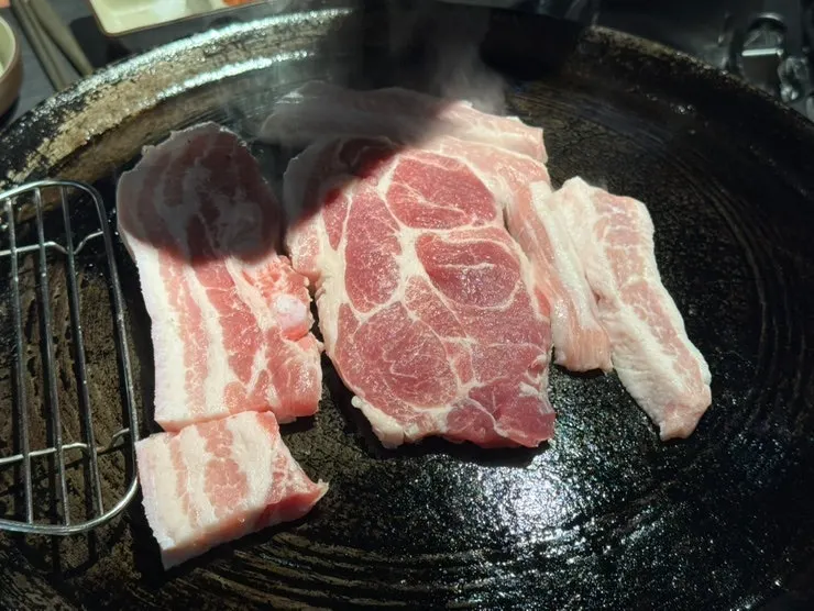 Staff grilling the assorted meat and vegetables