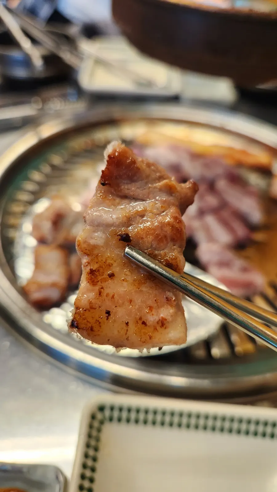 Kimchi grilled in pork fat alongside a piece of meat