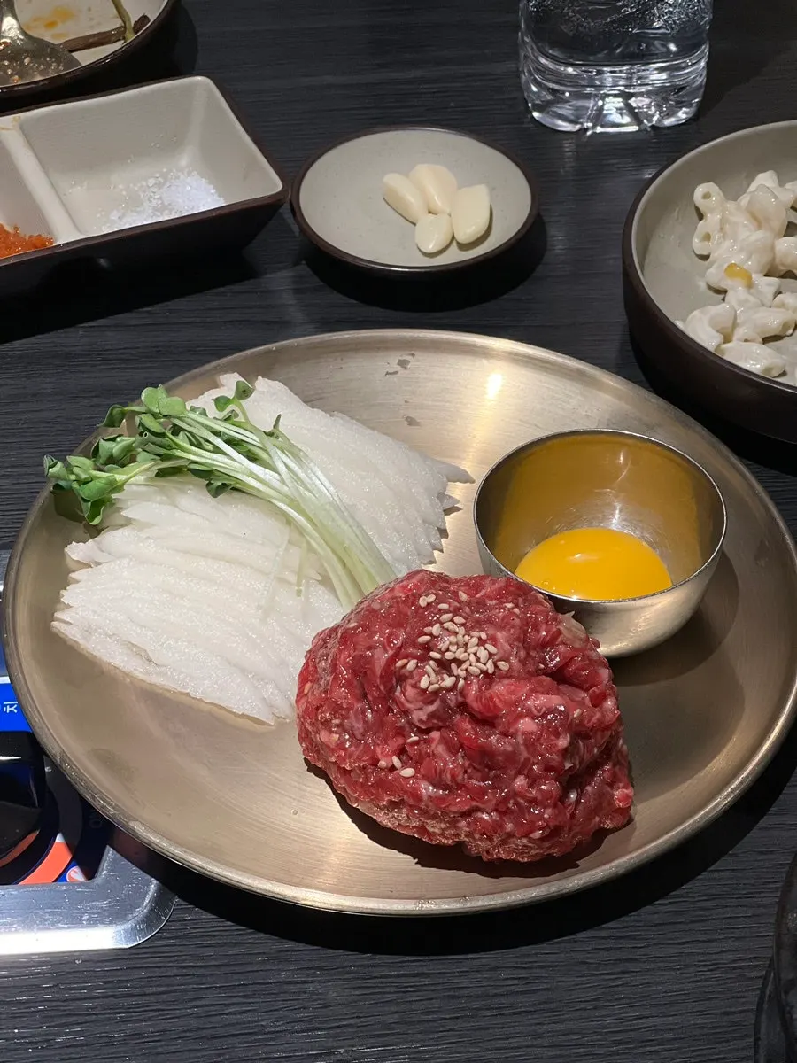 Full view of the cauldron-lid plate with meat and vegetables grilling together