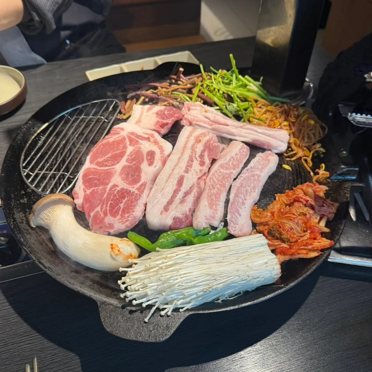 솥뚜껑 불판에 올라간 야채와 고기