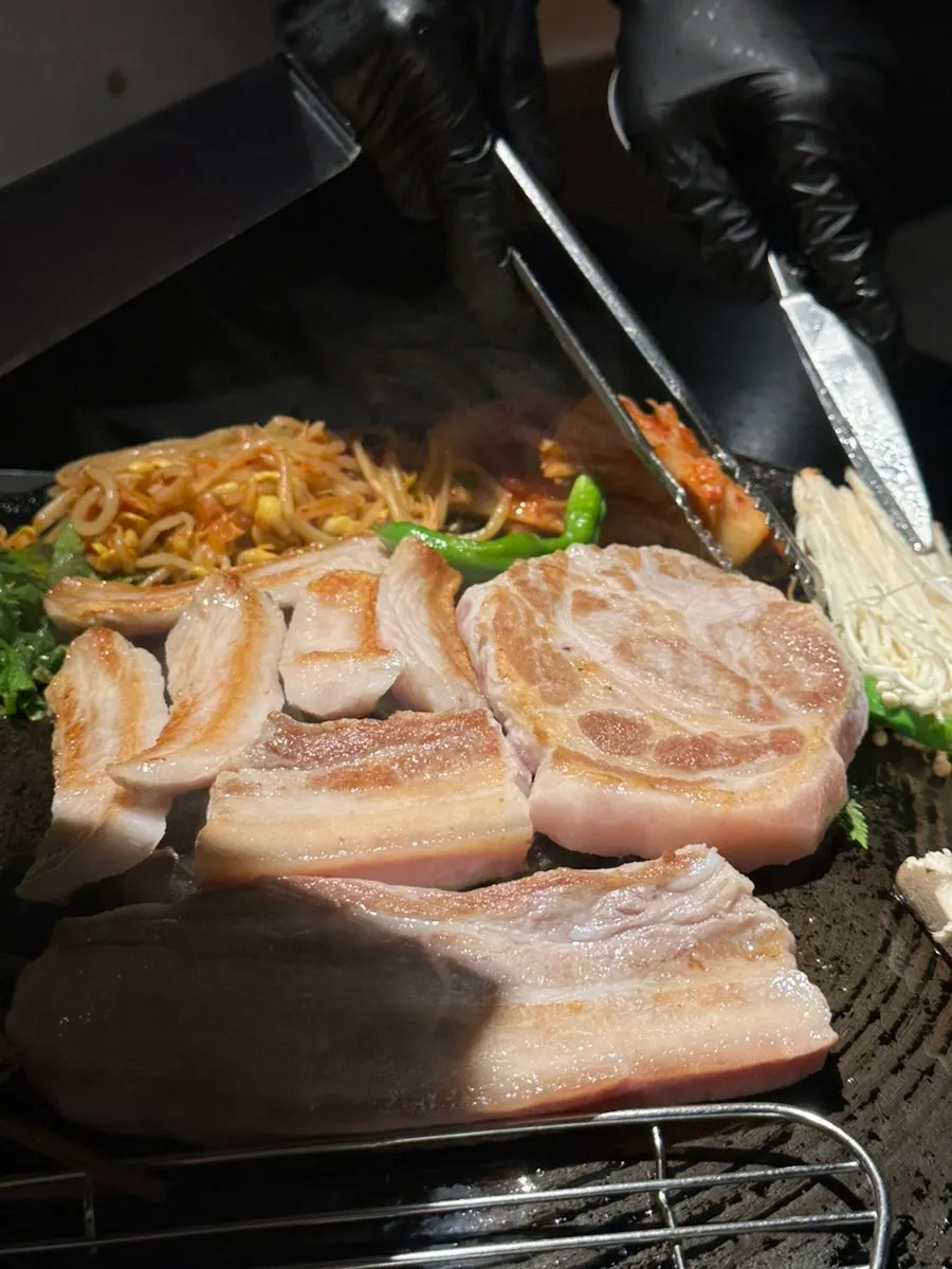 Kimchi, seasoned bean sprouts, and minari on the cauldron-lid griddle