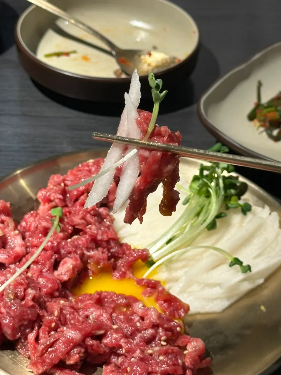 Bright red beef tartare topped with egg yolk