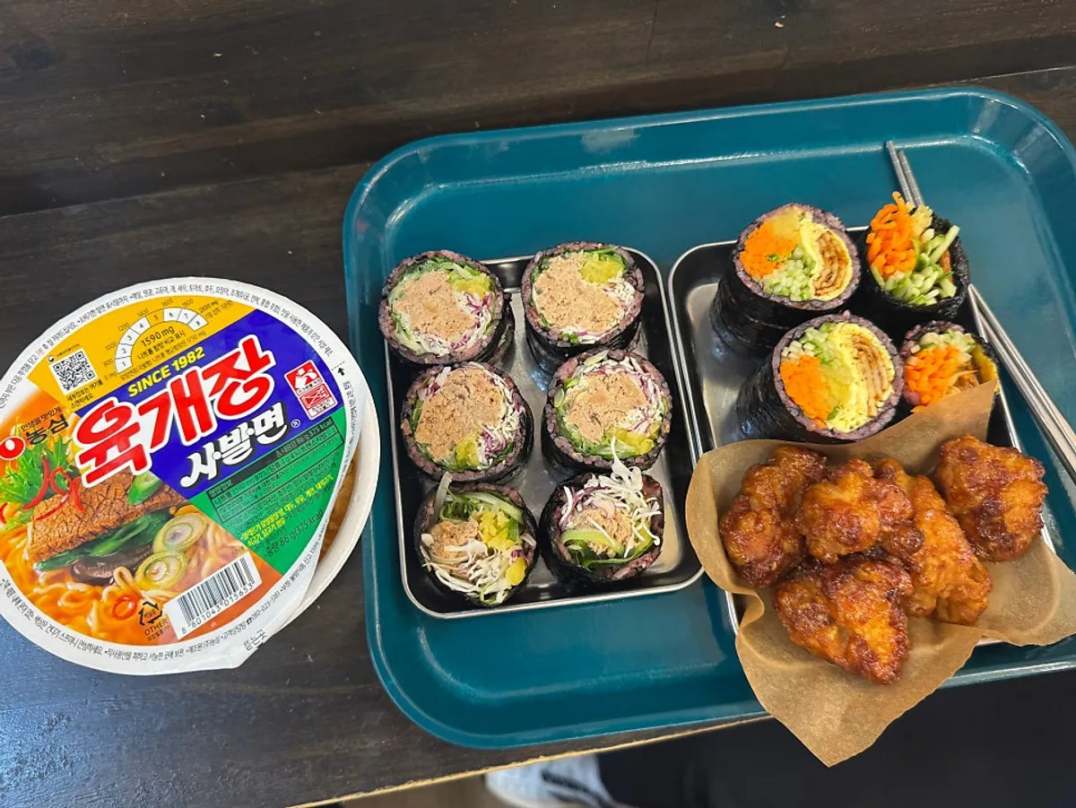 Jindo green onion tuna gimbap, Halls Gimbap dakgangjeong set, and cup noodles laid out