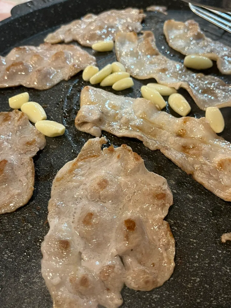 Golden-brown shaved pork with garlic cooking