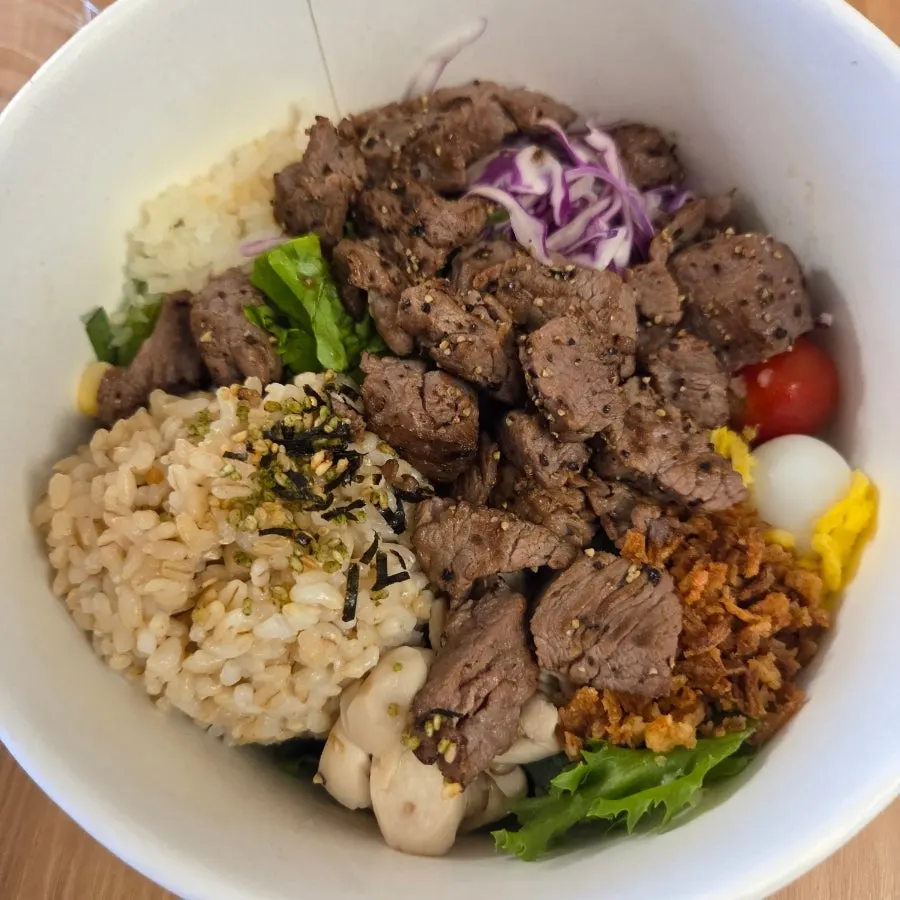 A tender piece of grilled steak picked up with chopsticks