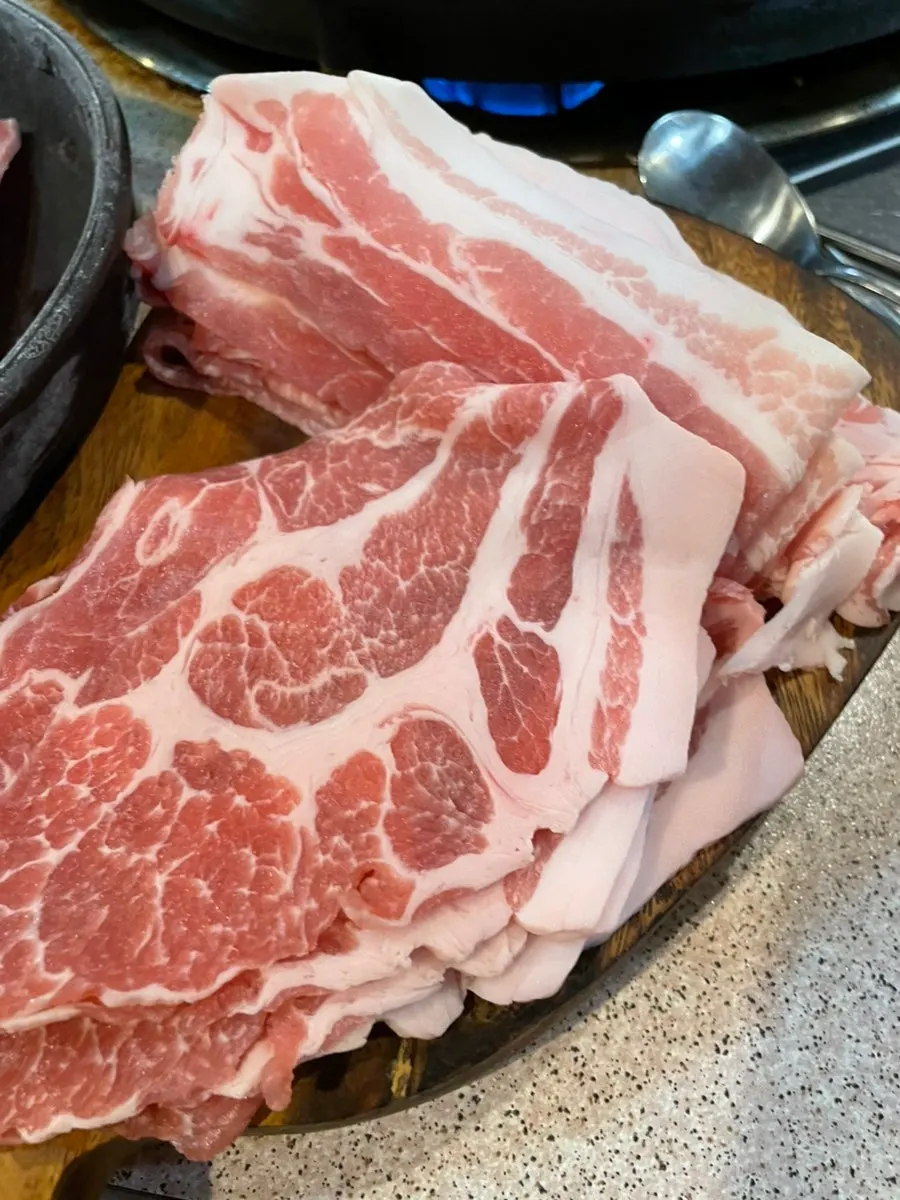 나무도마에 담긴 냉장 생대패삼겹과 생대패목살