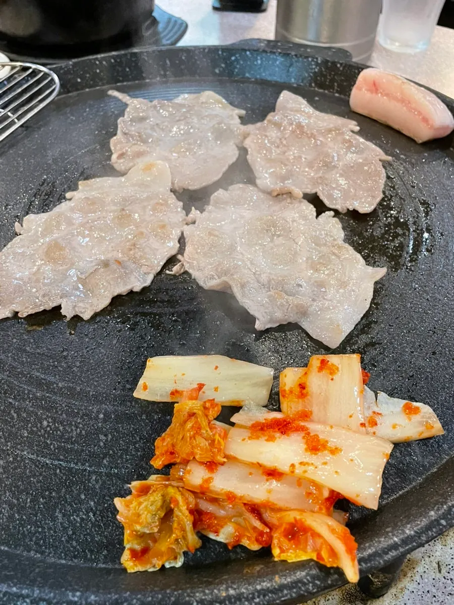 테이블에 놓인 순후추와 구워지는 고기