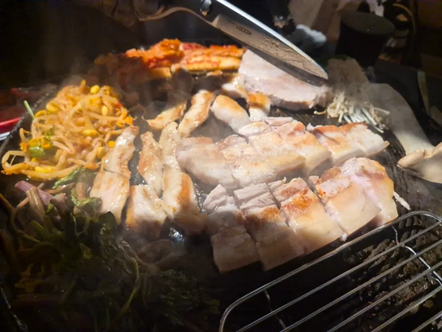 구워진 고기와 곁들임 반찬이 놓인 테이블
