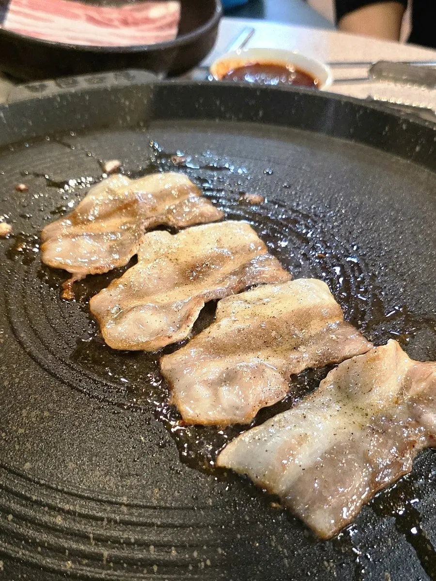 A piece of fat being used to oil up the grill