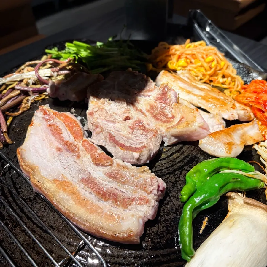 Pork belly cooking on the cauldron lid