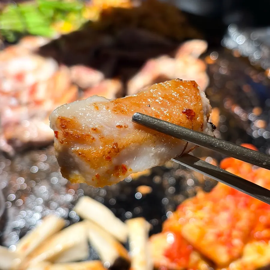 A piece of pork jowl picked up with chopsticks