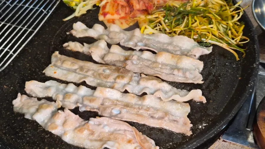 Pork belly grilling on the hot plate