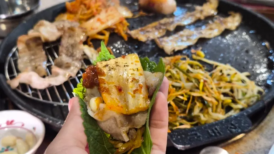 A perilla leaf wrap with grilled pork belly and vegetables