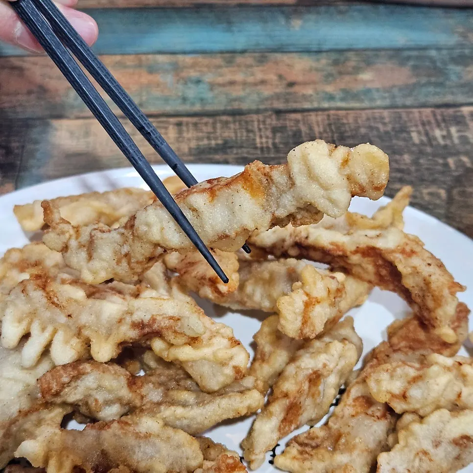 A piece of sweet-and-sour pork dipped in sauce