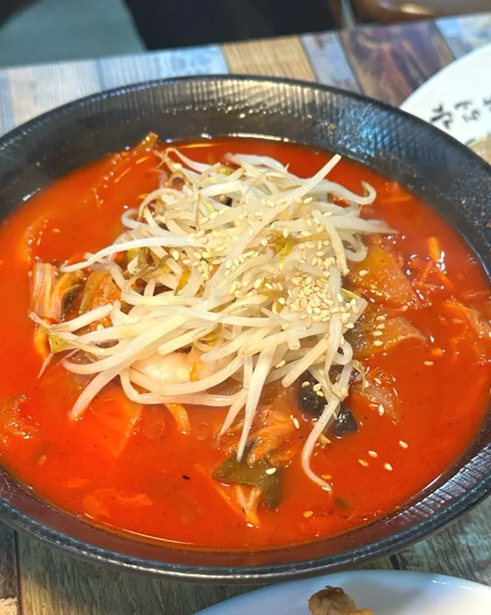 A bowl of jjamppong topped with plenty of bean sprouts