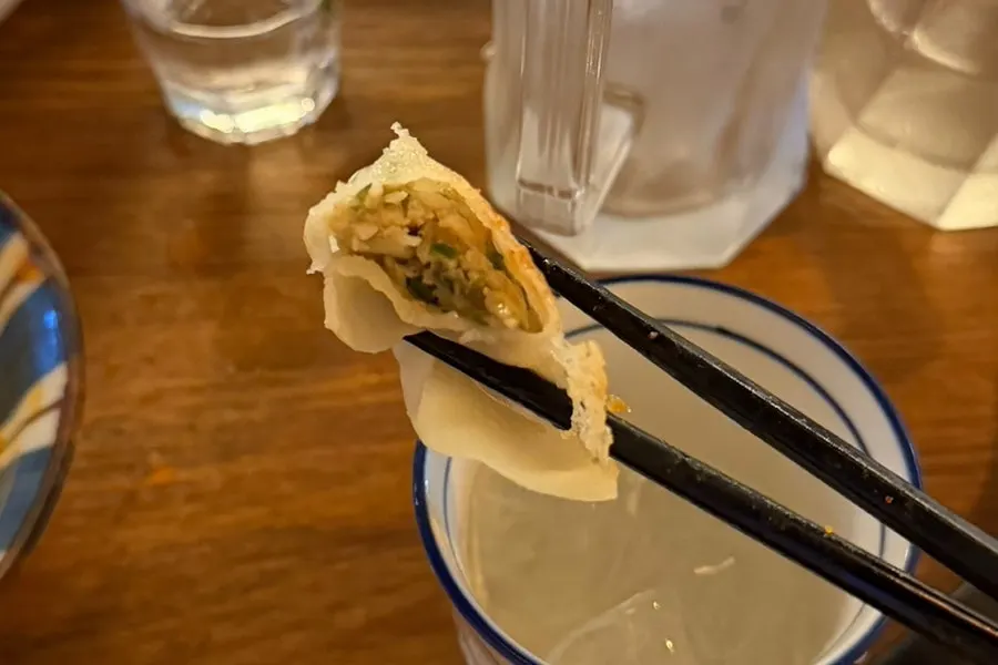 Cross-section of yakigyoza dipped in soy sauce