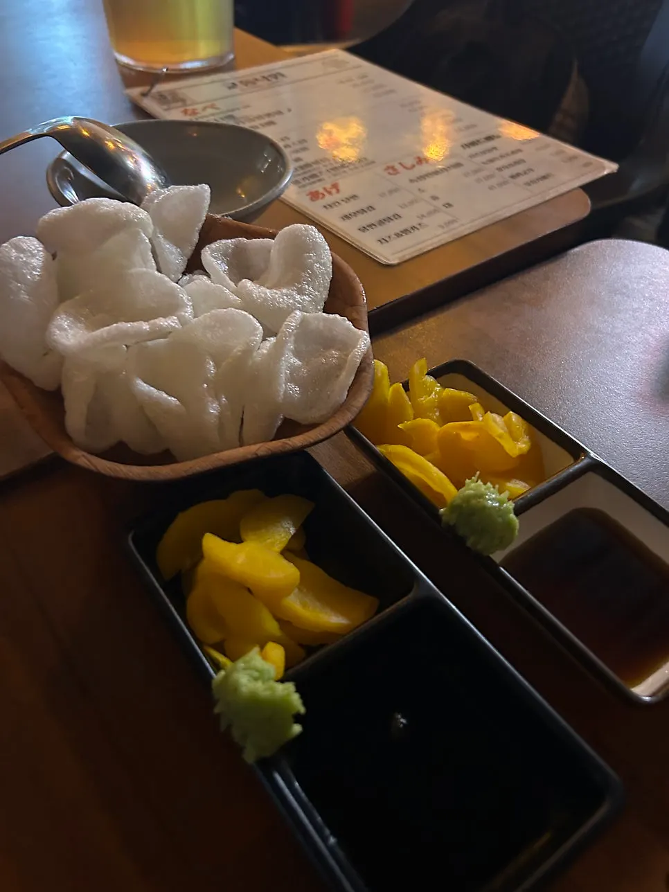 Basic table setting of shrimp chips, pickled radish, nabe sauce and wasabi