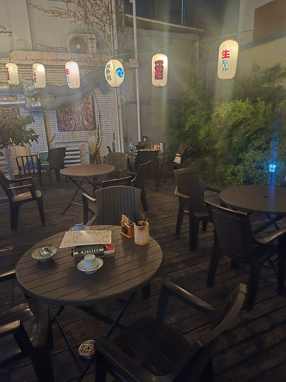 Semi-outdoor terrace seating hung with bare bulb lights