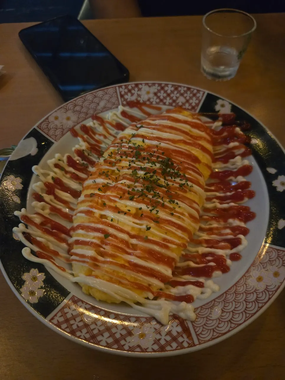 A plate of cheese omelet drizzled with sauce in a zigzag pattern