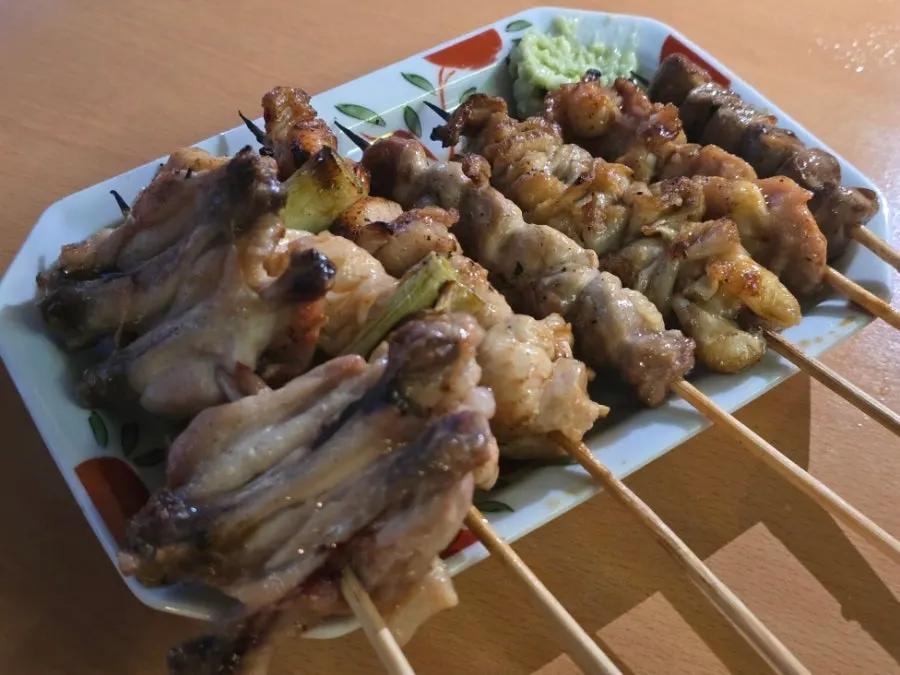 Charcoal-grilled skewers of different chicken parts