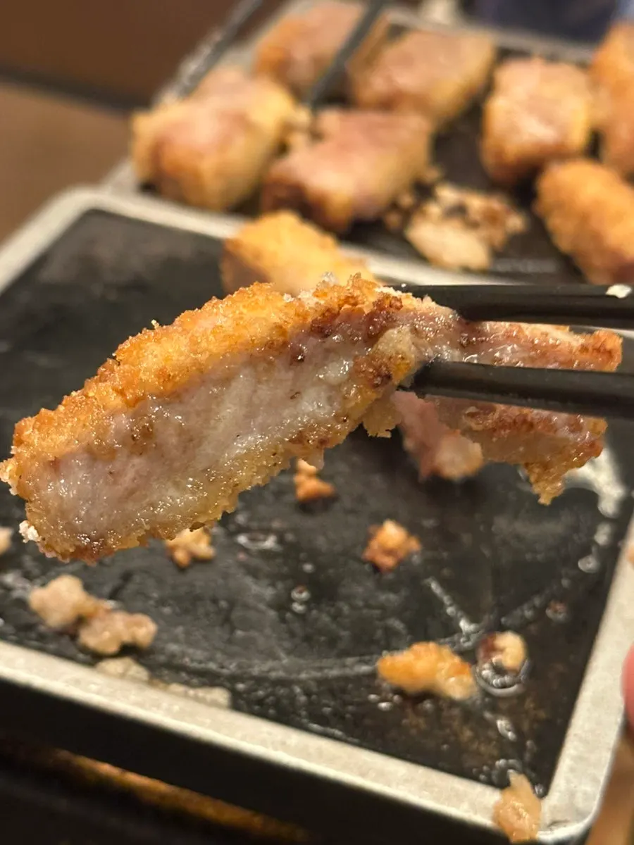 A piece of sirloin gyukatsu picked up with chopsticks