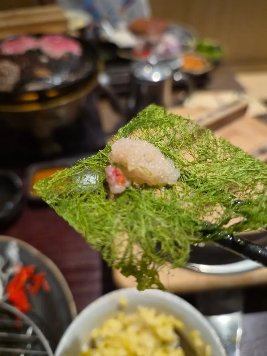 A bite of gim topped with grilled meat and pollock roe
