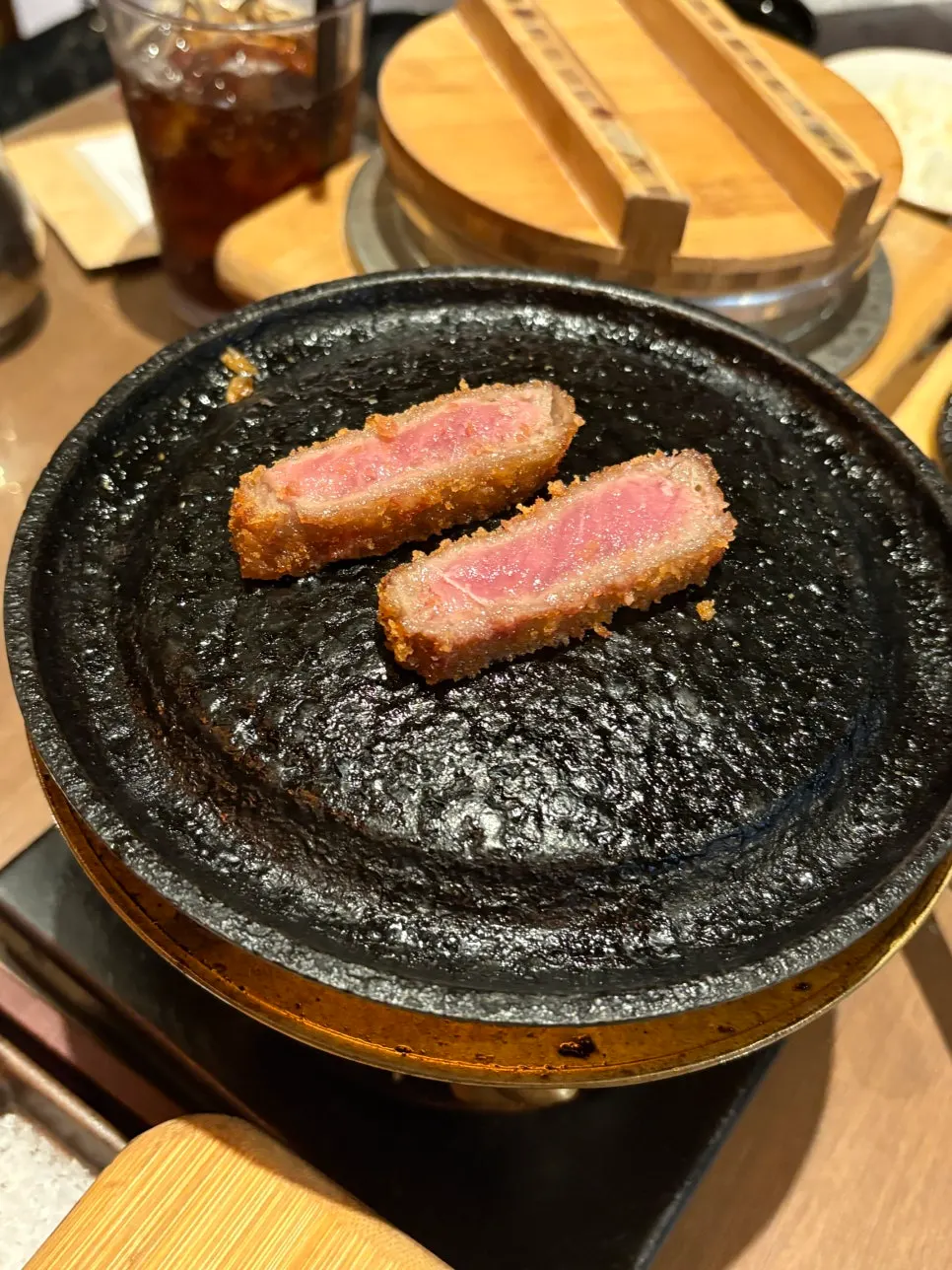 A piece of gyukatsu being grilled on a personal brazier