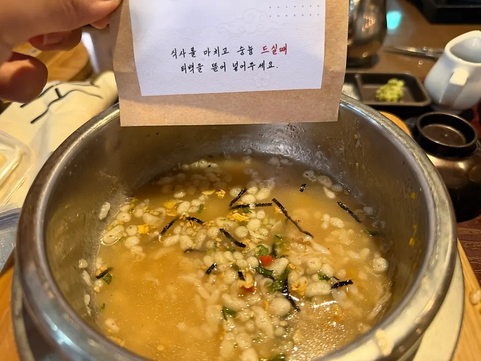 Finishing the crispy rice with broth and flake topping