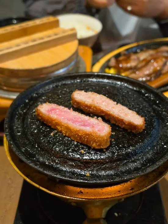 A slice of smoked gyukatsu with a pink cross-section