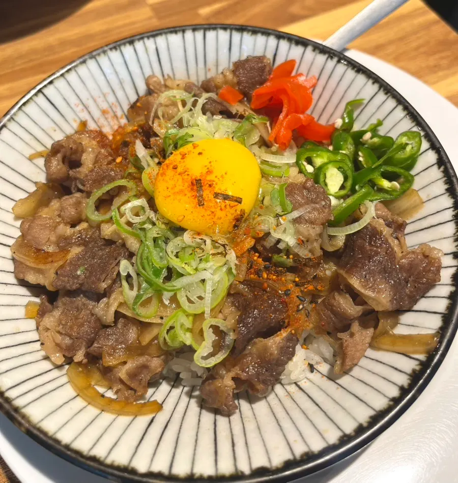 Mentsuru gyudon topped with egg yolk and chili