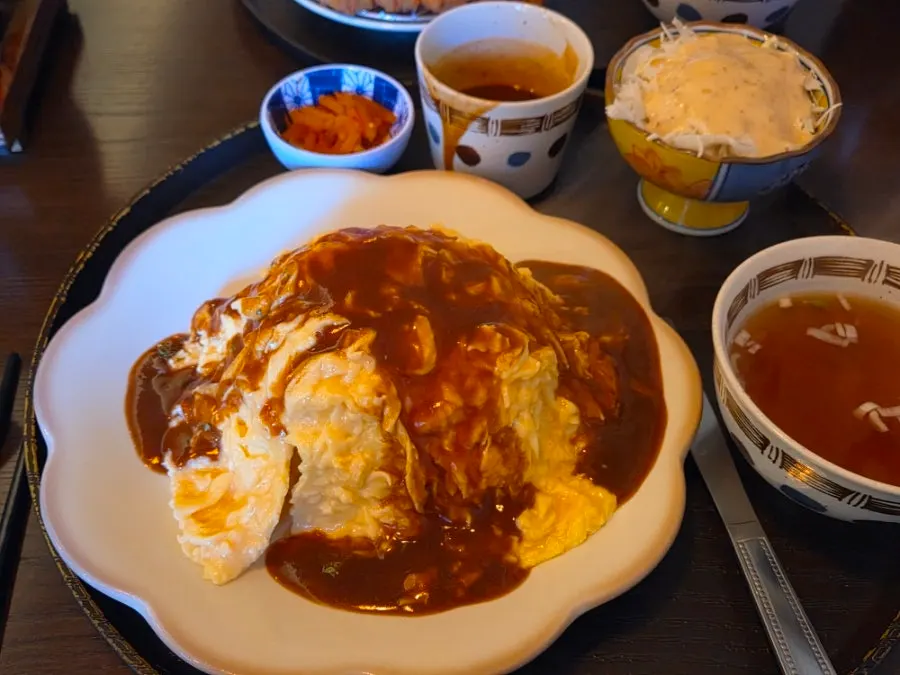 Hamburger steak omurice split in half with sauce poured over