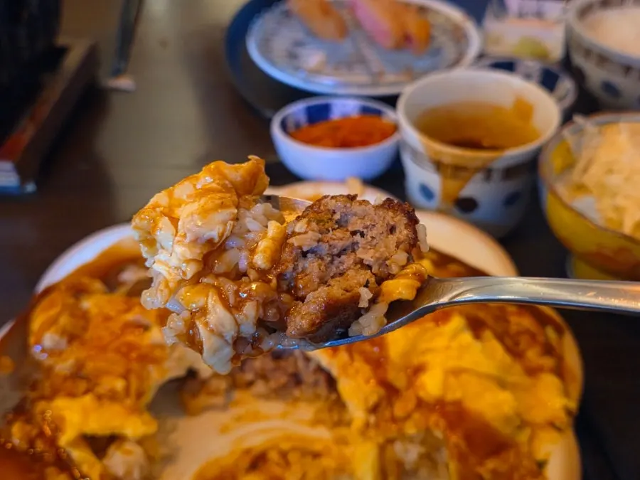 Cross-section of the omurice showing the thick hamburger steak