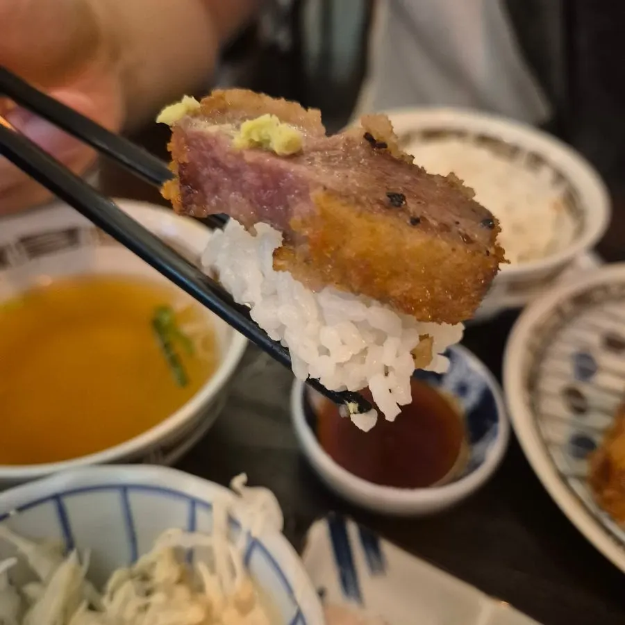 A spoonful of omurice eaten alongside the gyukatsu