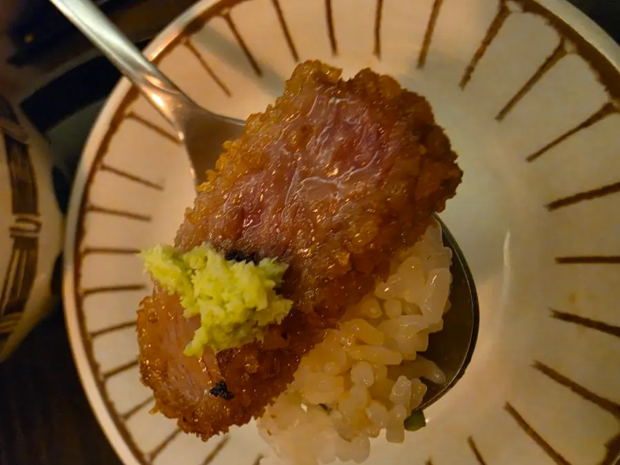 A piece of gyukatsu topped with wasabi