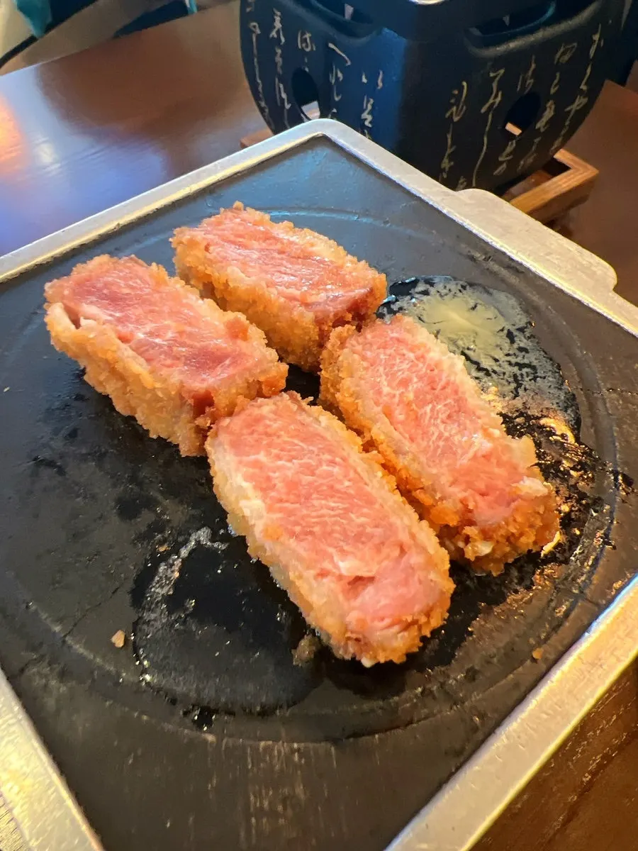 Piece of sirloin gyukatsu grilling on the fire