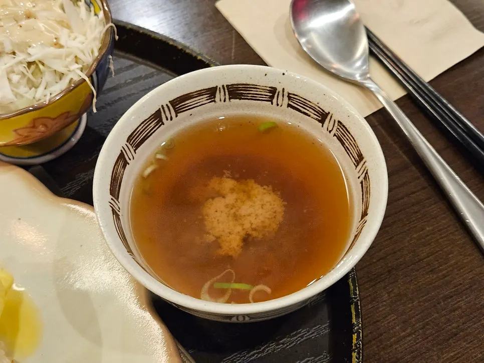 Clear broth served alongside the gyukatsu