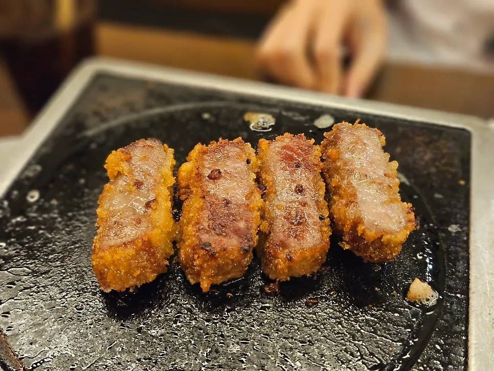 Gyukatsu sizzling on the grill with butter melting on top