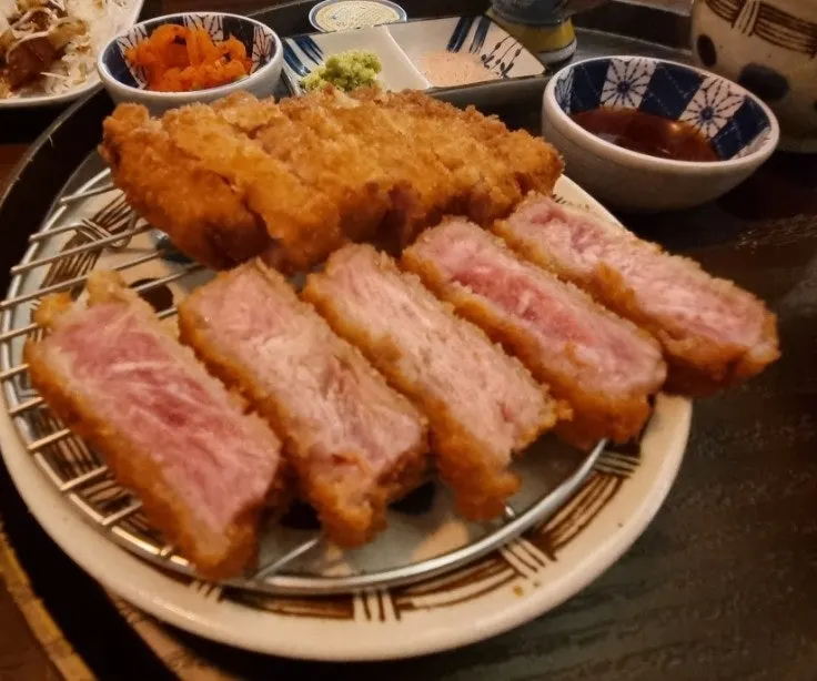 A piece of tenderloin gyukatsu dipped in sauce