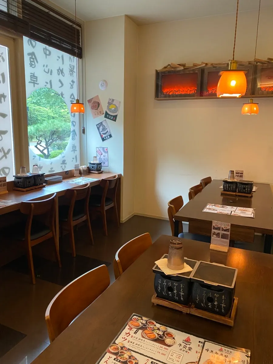 Interior with wood-tone tables and orange lamps